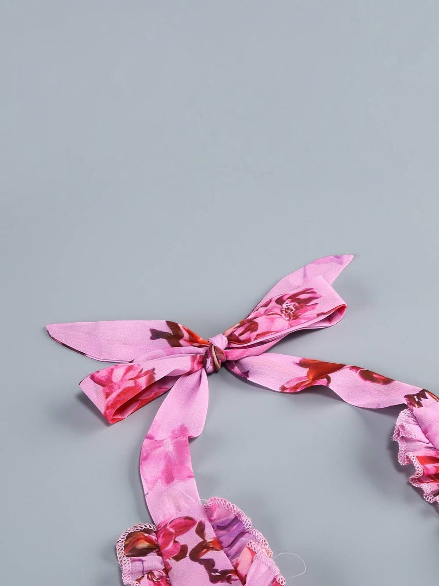 Mialur pink floral maxi dress featuring a halter neckline with a delicate tie bow and cascading ruffle details.