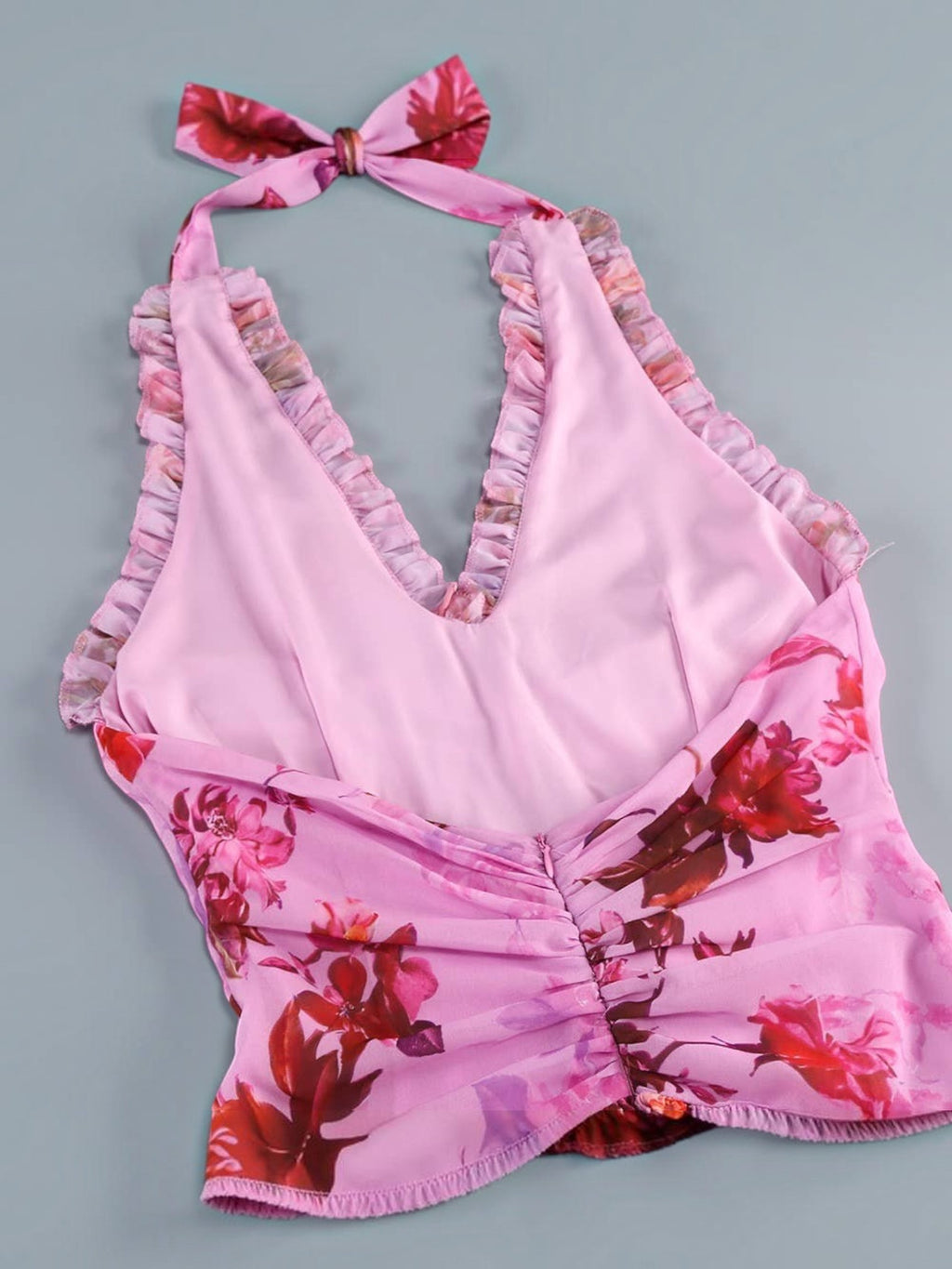 Mialur pink floral halter maxi dress with ruffled trim and a back tie detail on a grey background