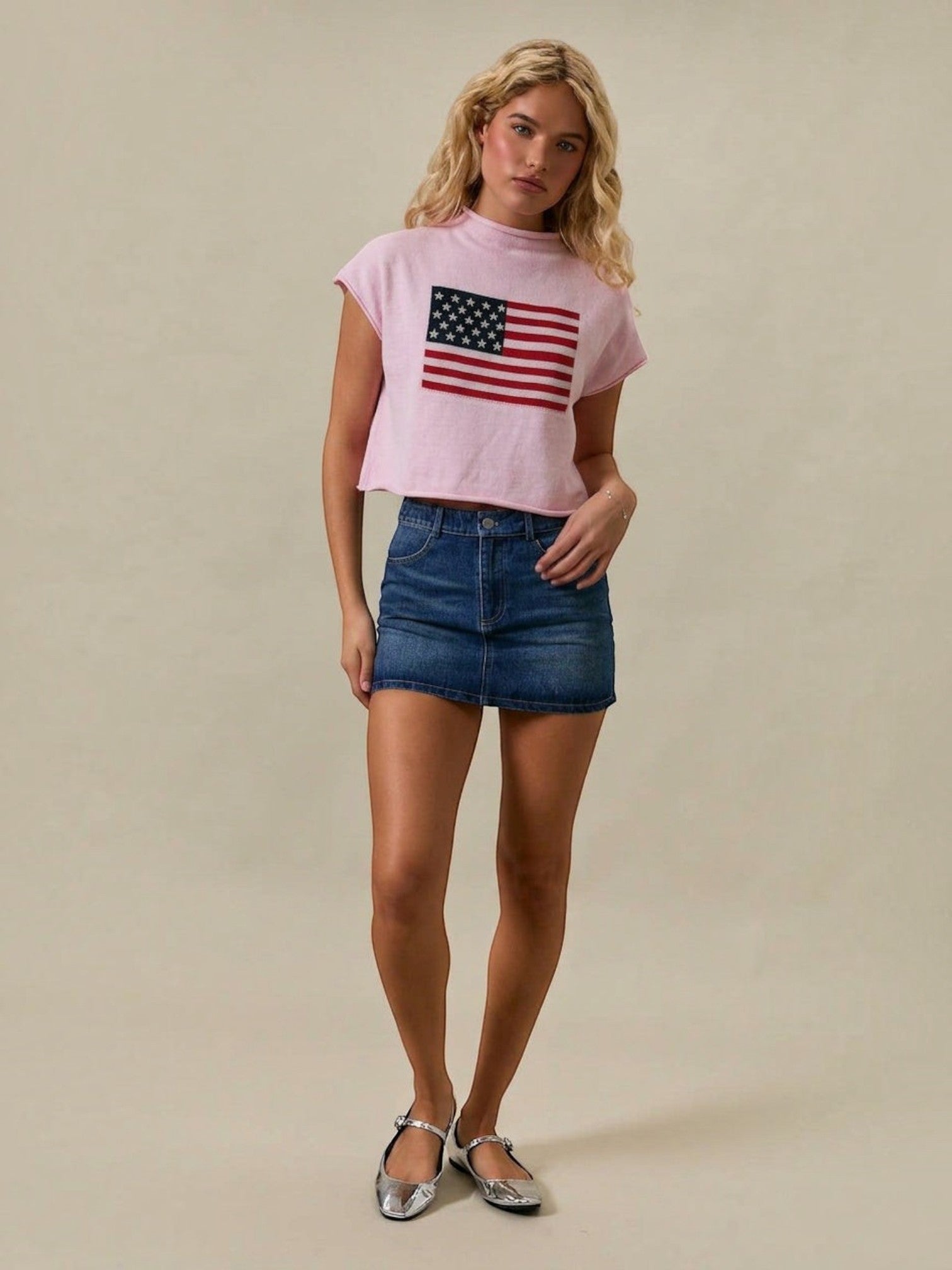 Mialur pink mock neck top with American flag graphic, featuring a relaxed drop shoulder fit worn with a denim skirt.