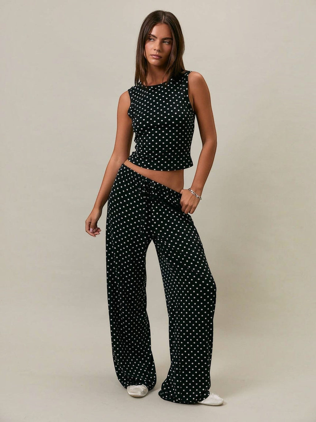 Model wearing Mialur black and white polka dot stretch knit tank top and matching wide-leg trousers