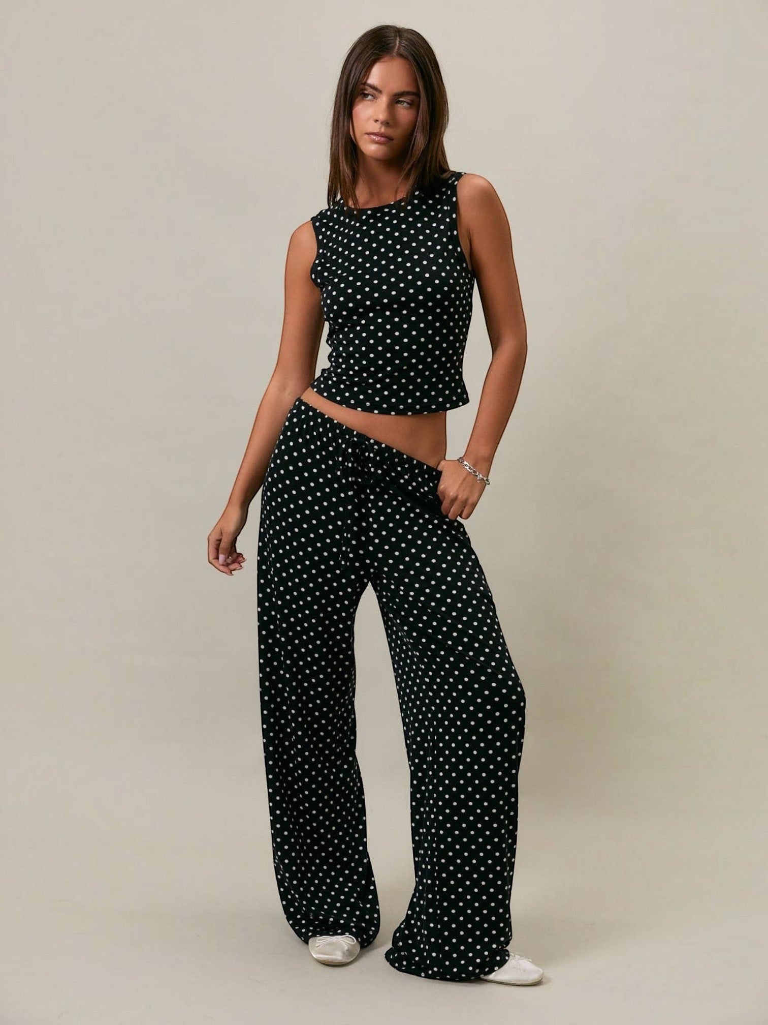 Model wearing Mialur black and white polka dot stretch knit tank top and matching wide-leg trousers