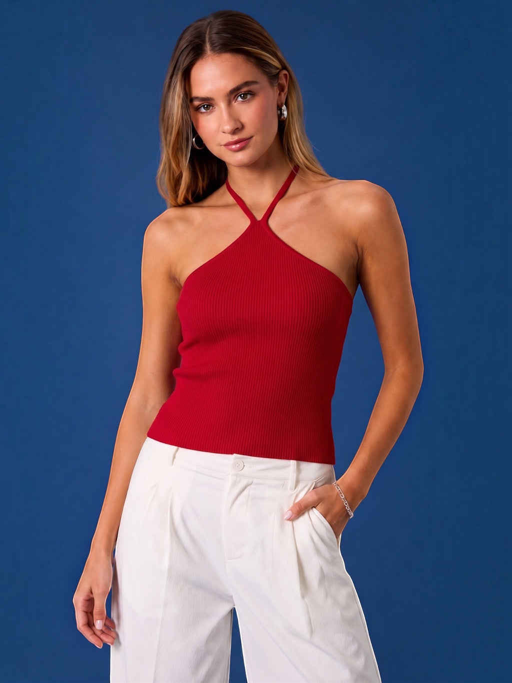Mialur red ribbed halter top worn by a model with white trousers against a blue background