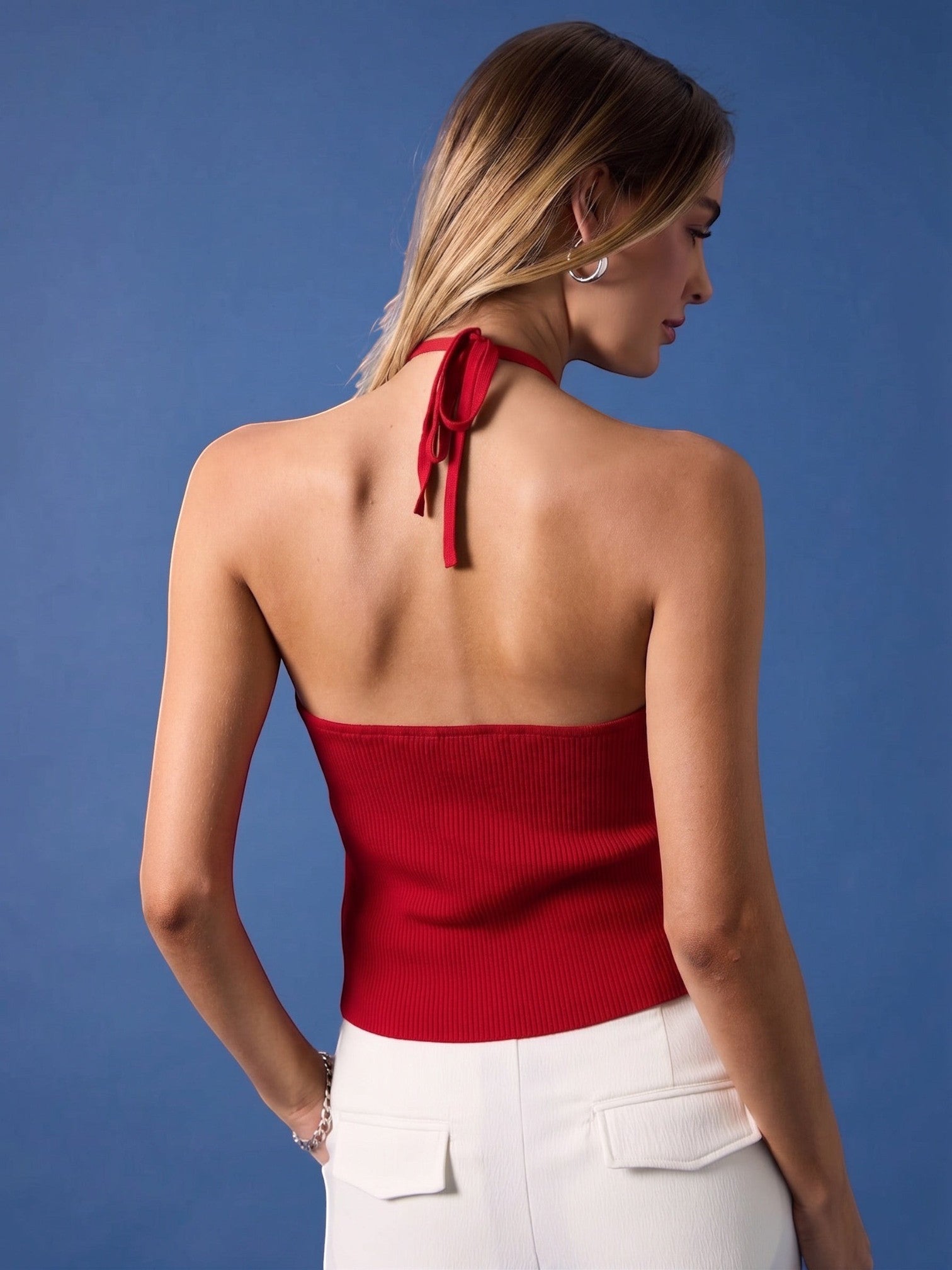 Mialur red ribbed halter top with a tie-neck design worn by a model against a blue background, back view.