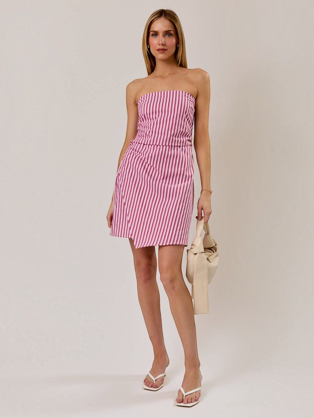 Model wearing Mialur red and white striped strapless mini dress with ruched bodice and lightweight fabric