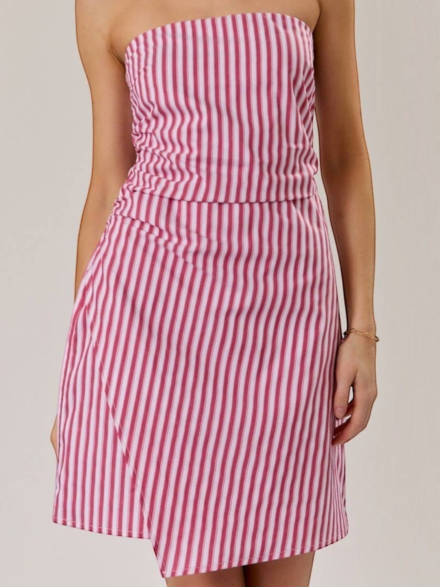 Model wearing a Mialur red and white vertical striped strapless mini dress with a flattering ruched bodice.