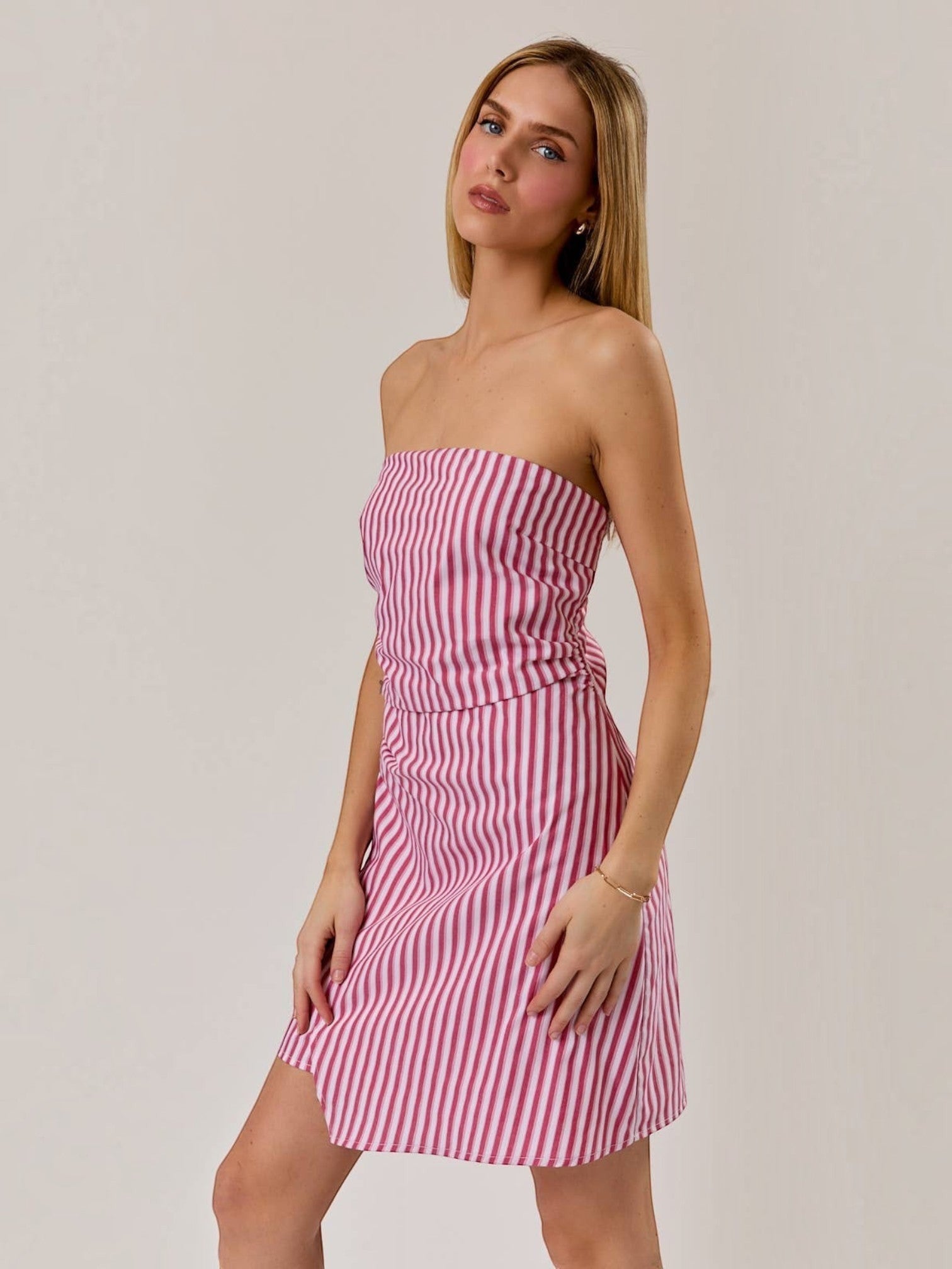 Model wearing a Mialur red and white striped strapless mini dress with a ruched bodice against a neutral background.