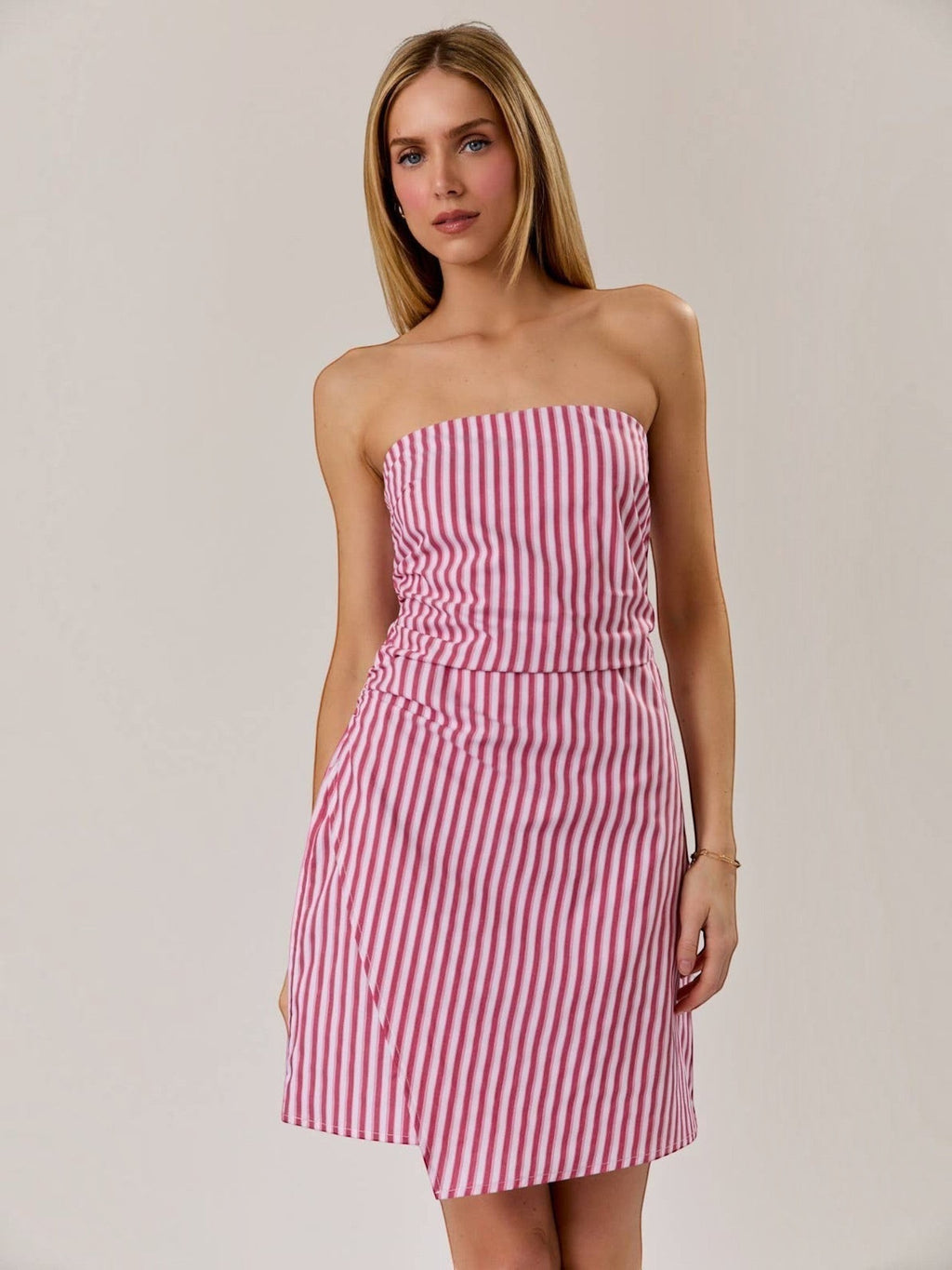Model wearing a Mialur red and white vertical striped strapless mini dress with a flattering ruched bodice