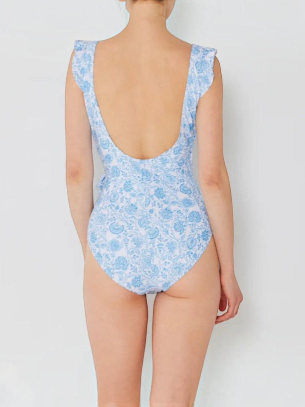 Back view of Mialur Santorini floral one-piece swimsuit in soft blue and white with ruffled shoulder straps.