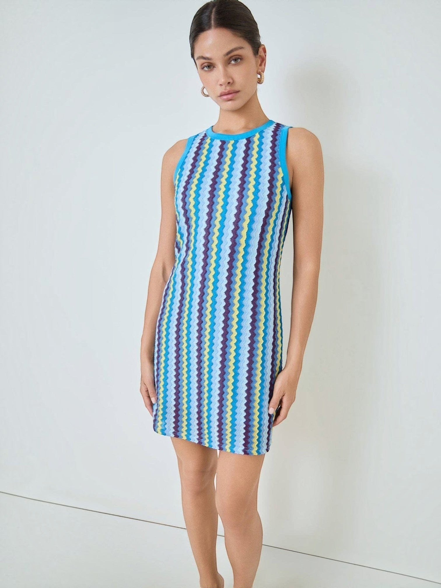 Mialur Santorini knit mini dress featuring a vibrant blue zigzag pattern with yellow and purple stripes on a model