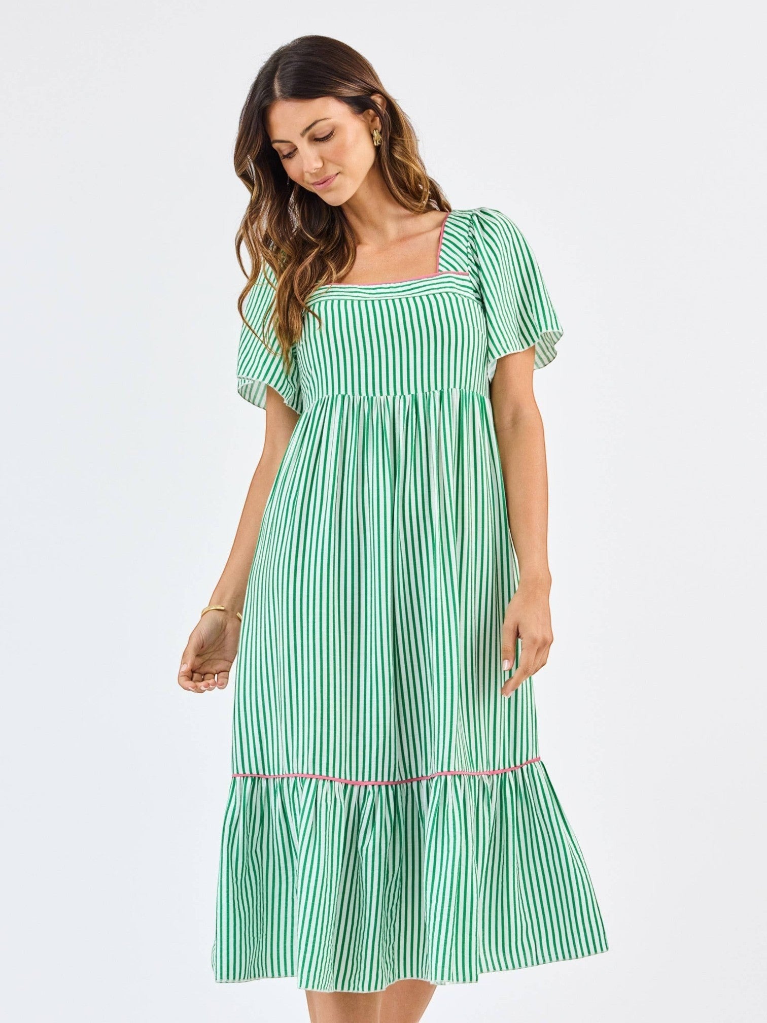 Model wearing Mialur Savannah midi dress in green and white vertical stripes with square neckline and puff sleeves