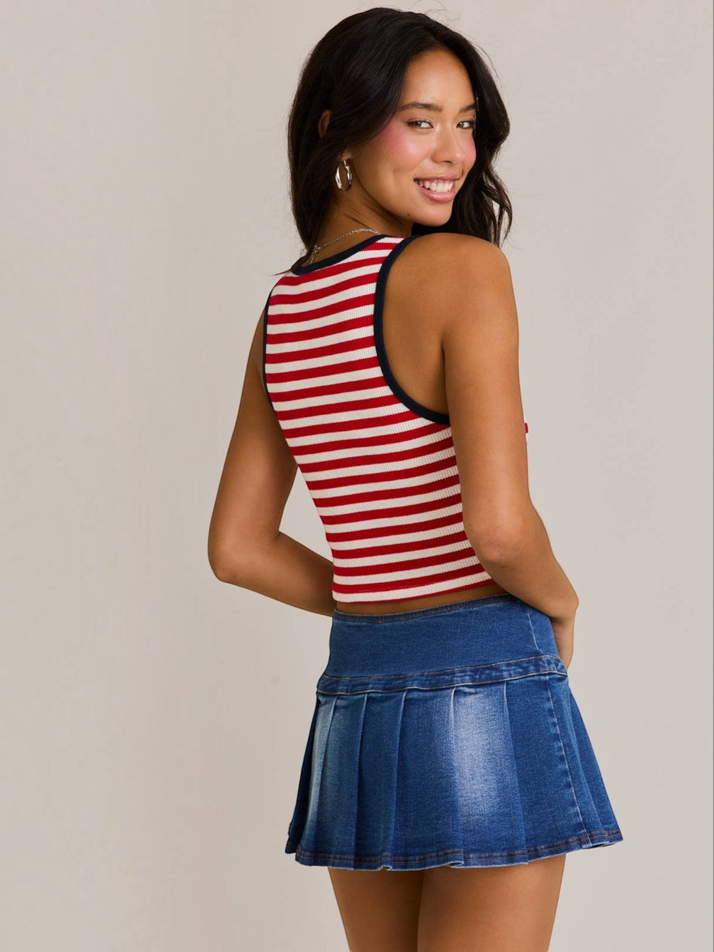 Mialur cropped tank top with red and white horizontal stripes and navy trim, worn by a smiling model with a denim skirt
