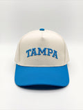 Mialur Tampa Coastal Hat in cream with a blue brim and blue embroidered TAMPA lettering on the front.