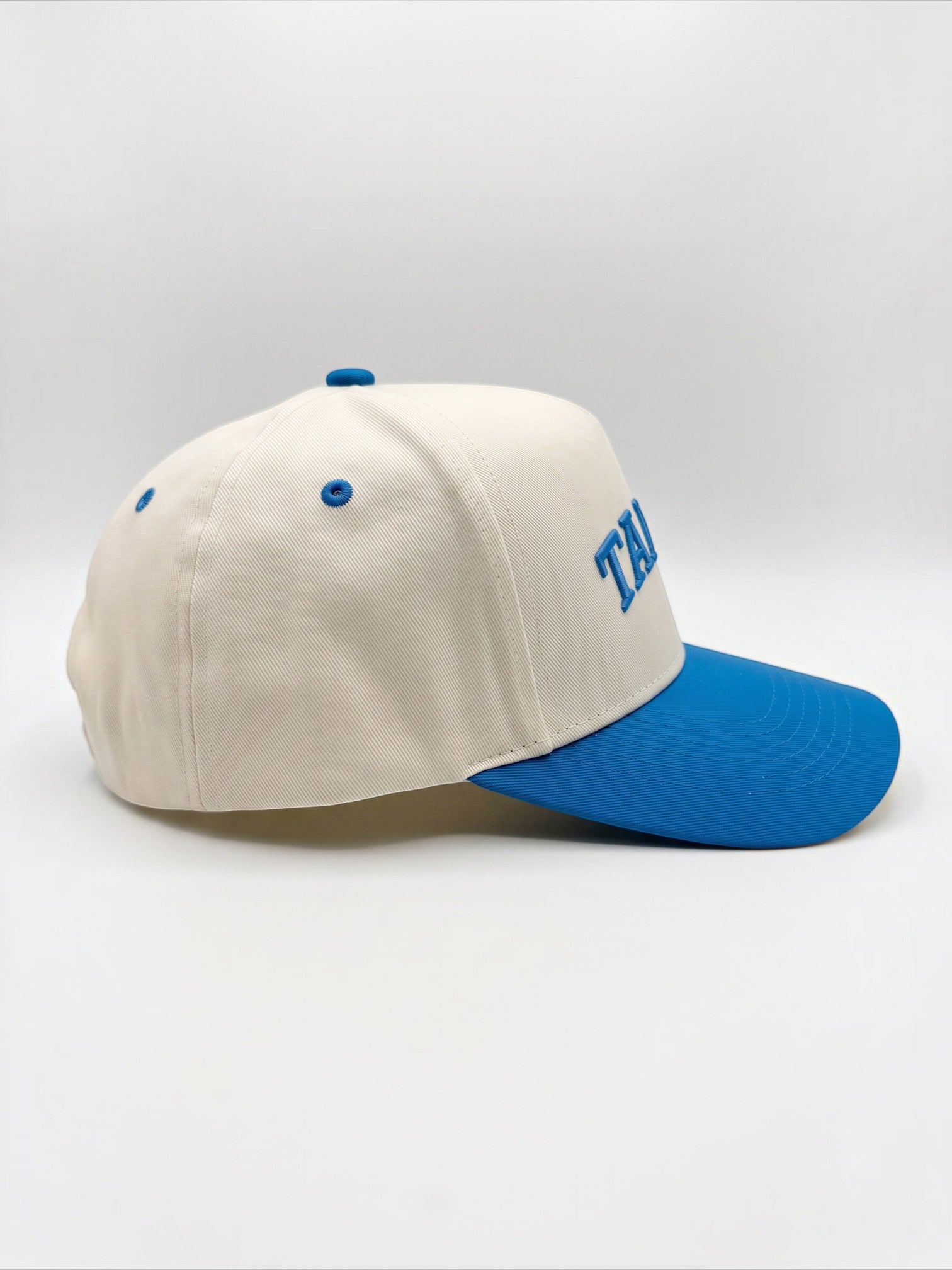 Mialur Tampa Coastal Hat in cream with a blue curved brim and embroidered blue TAMPA lettering on the side profile.