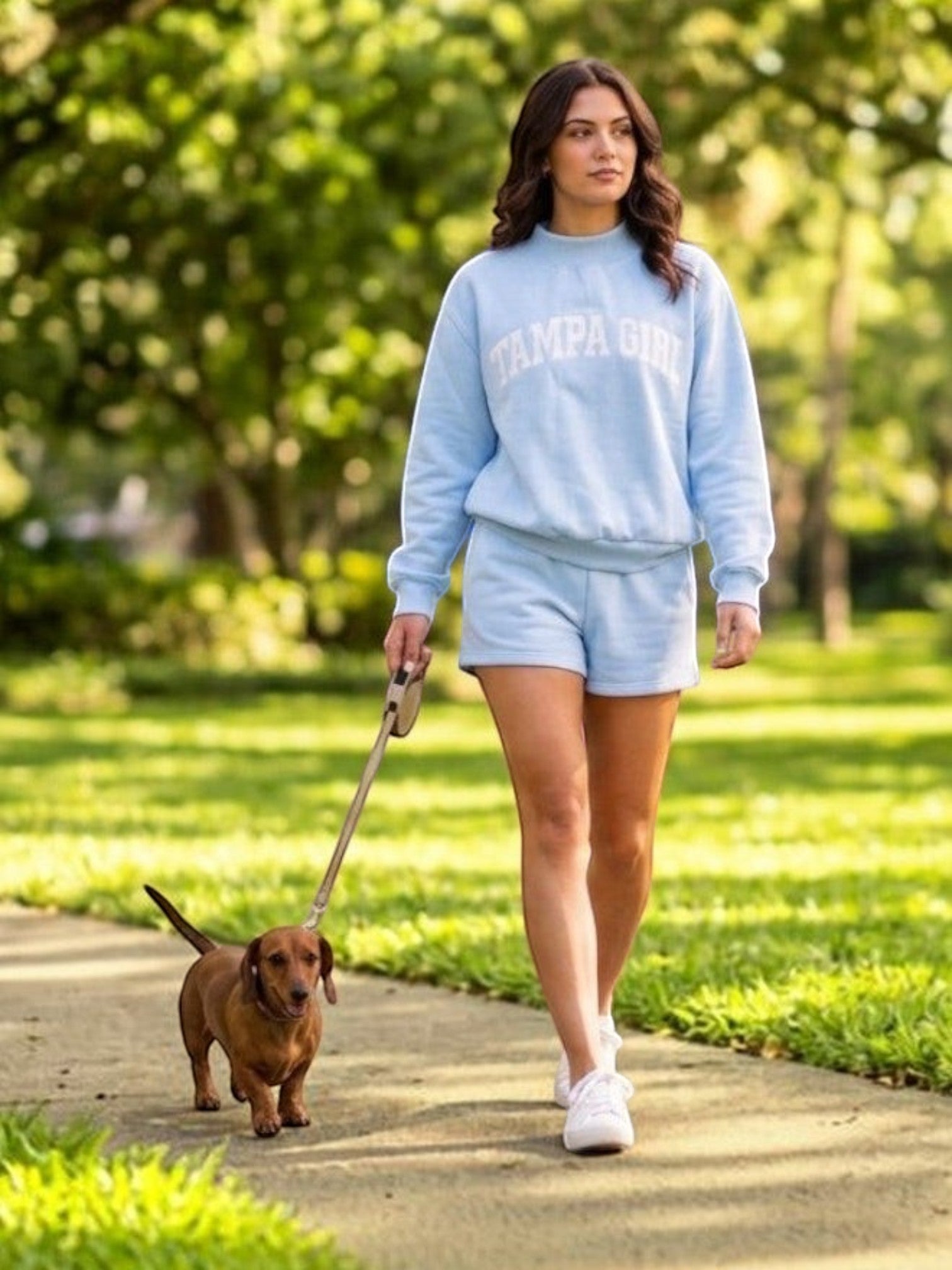 Mialur light blue mock neck sweatshirt and shorts set with Tampa Girl lettering worn by a woman walking a dog.