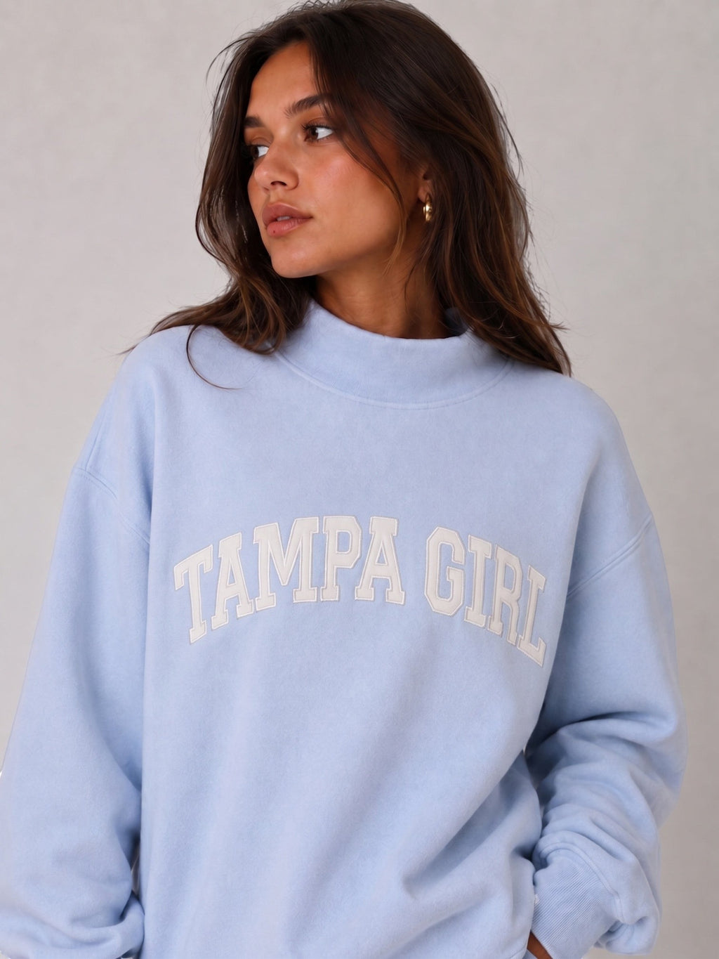 Mialur light blue mock neck sweatshirt with white TAMPA GIRL lettering worn by a model in a casual, sporty style.