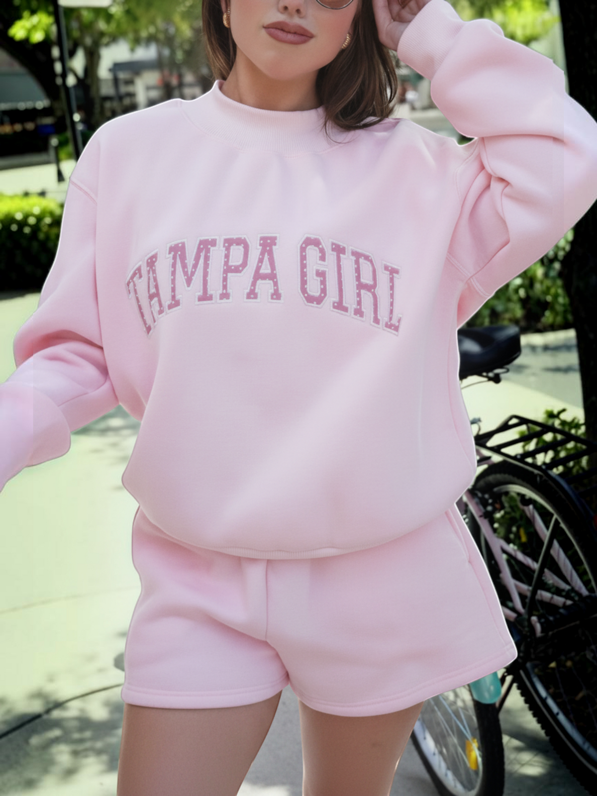 Mialur light pink mock neck sweatshirt and shorts set with white Tampa Girl lettering worn by a woman outdoors