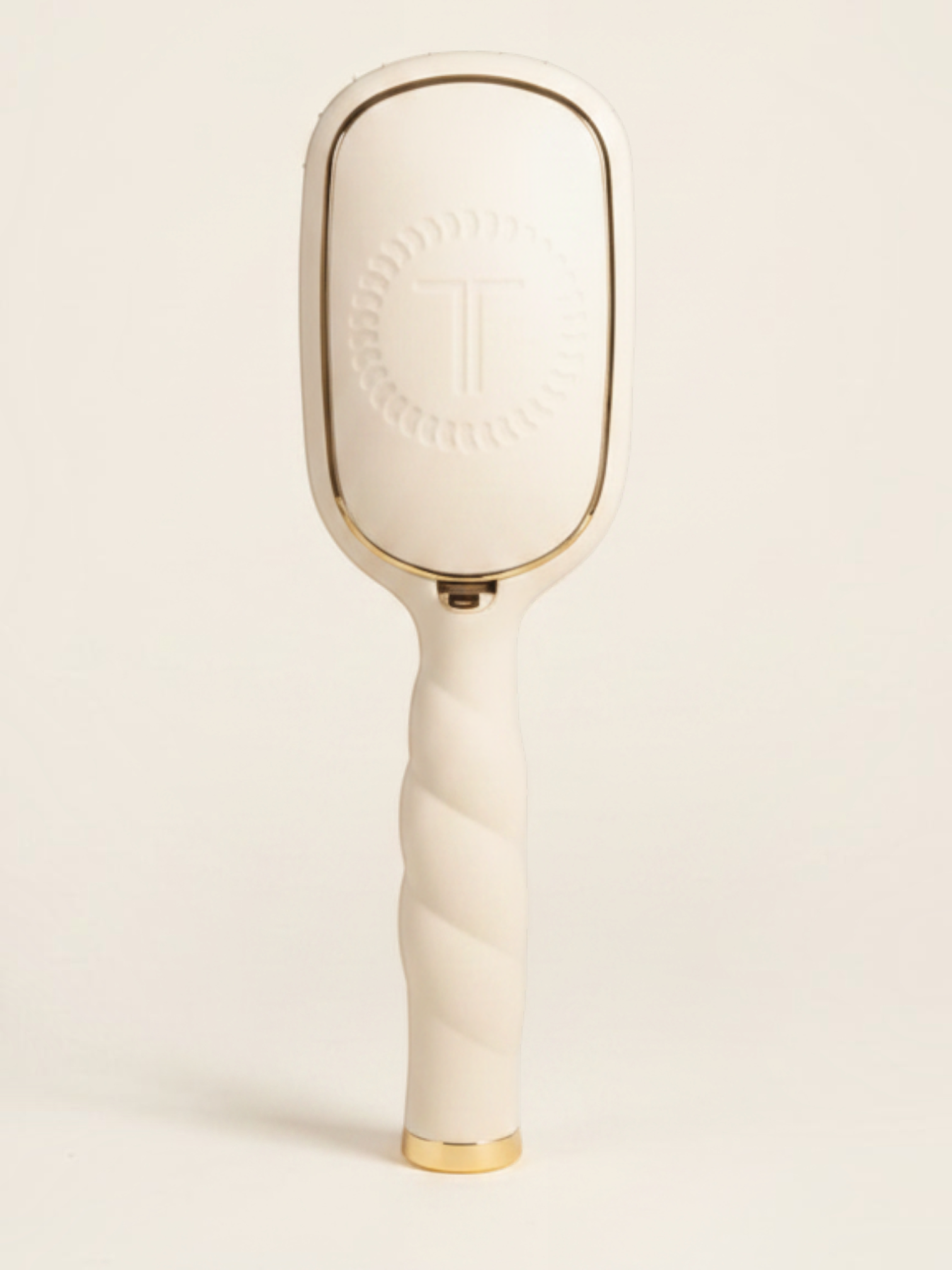 Mialur TELETIES tan boar bristle hair brush with a coil-inspired handle, gold accents, and a sleek, modern design.