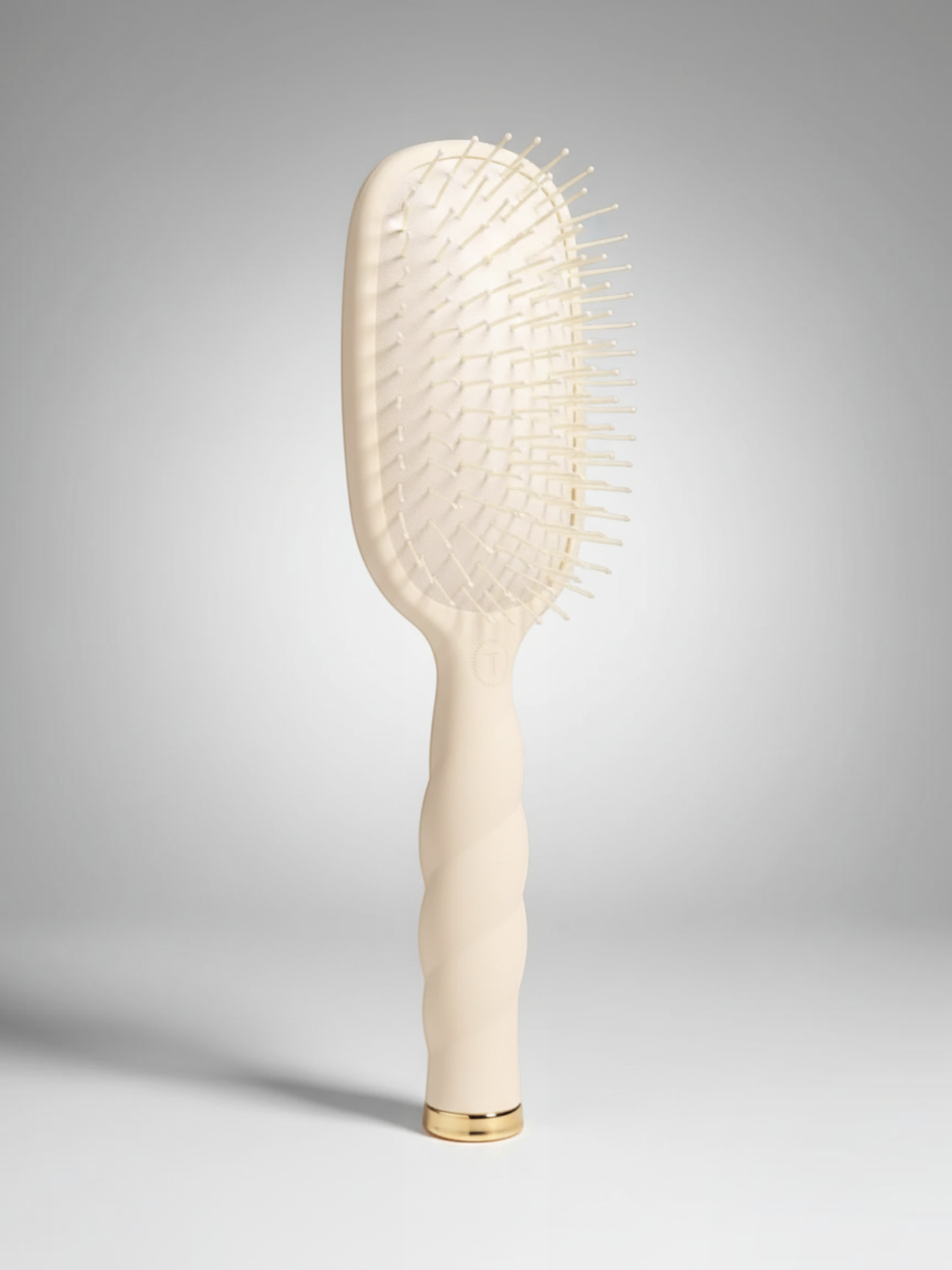 Mialur TELETIES tan detangler hair brush for medium hair with a coil-inspired grip and gold base detail.