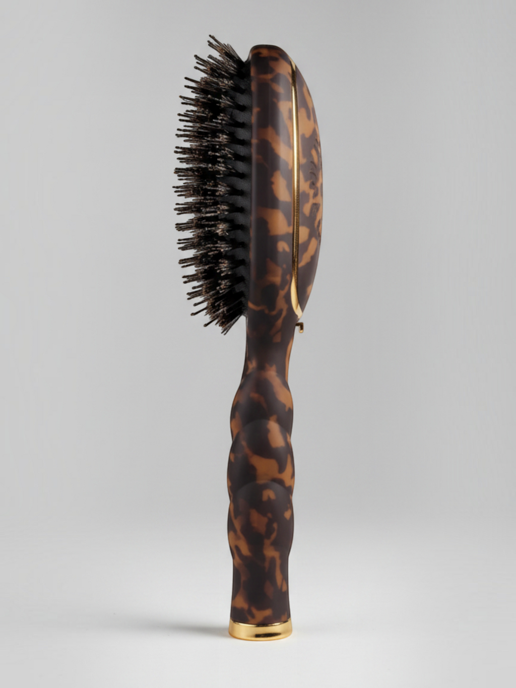 Mialur TELETIES boar bristle hair brush in tortoise pattern with a coil-inspired grip and gold accents.
