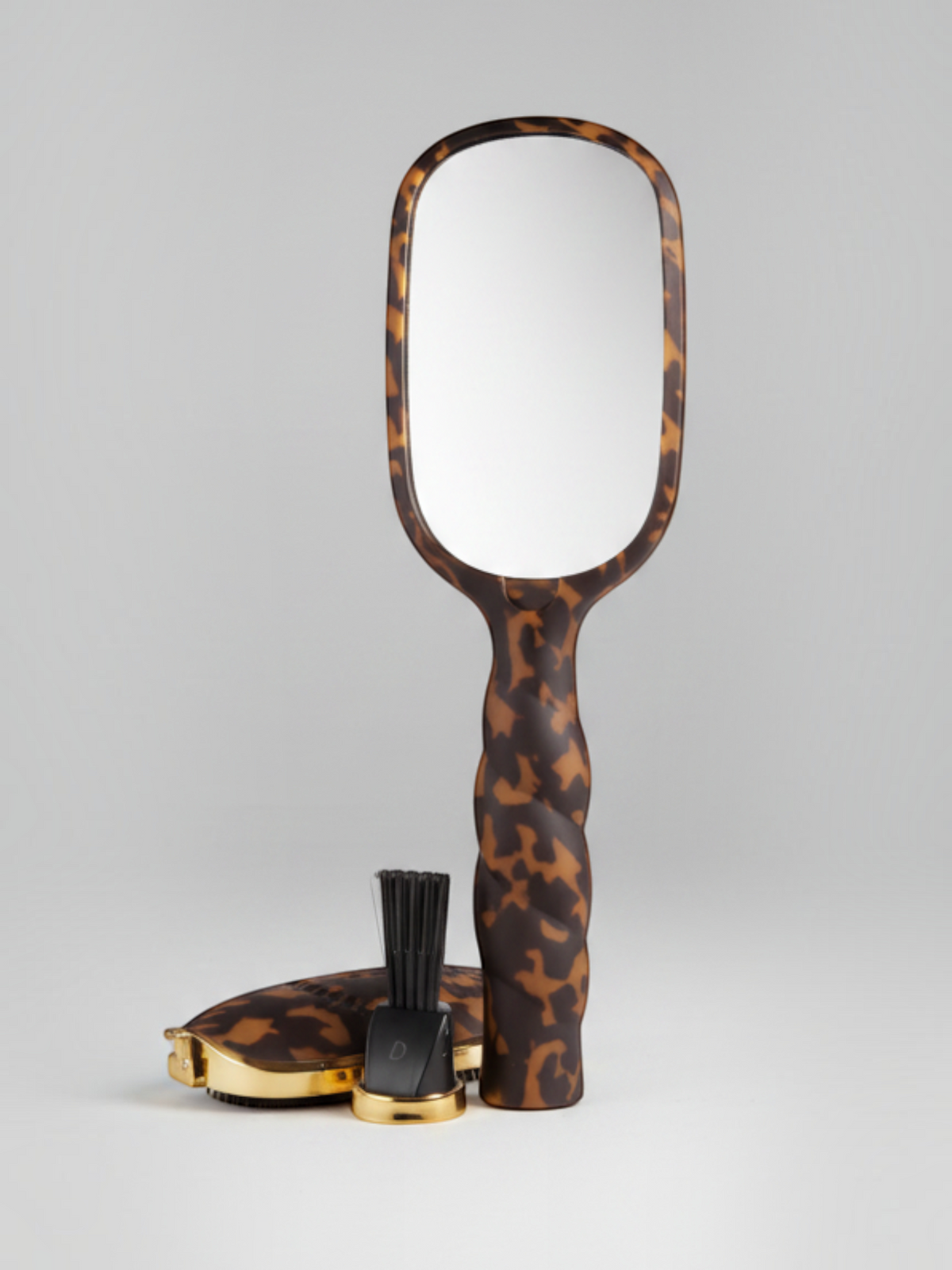 Mialur TELETIES tortoise shell hair brush with built-in mirror, gold hair pick, and coil-inspired handle design.