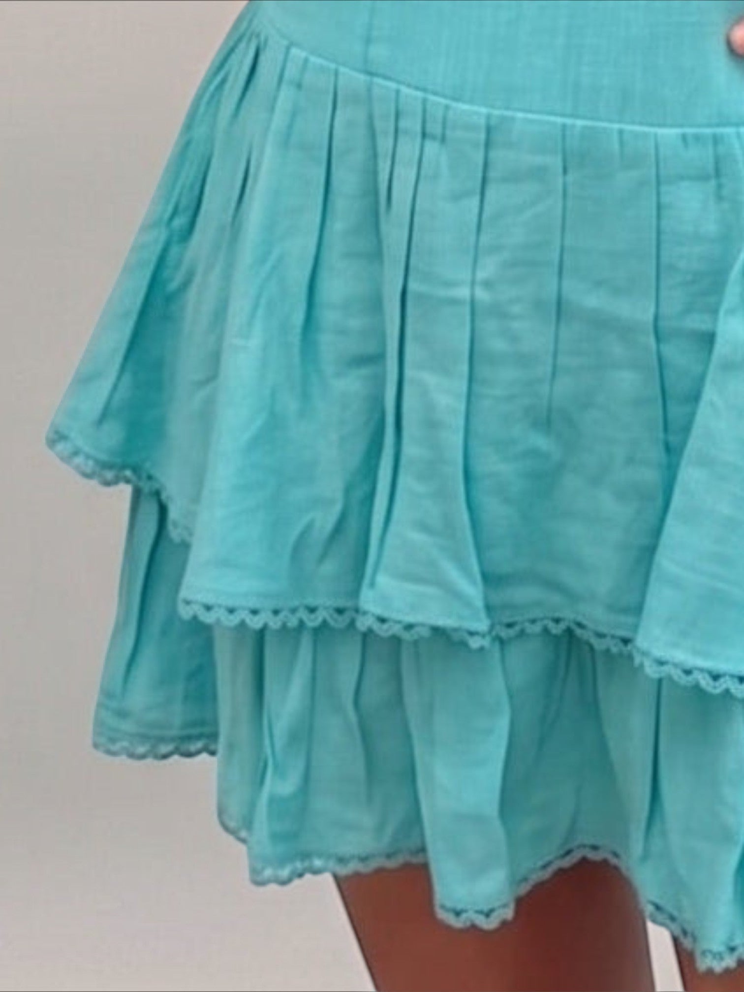 Mialur turquoise mini dress with a tiered skirt and delicate scalloped trim detailing on a light background