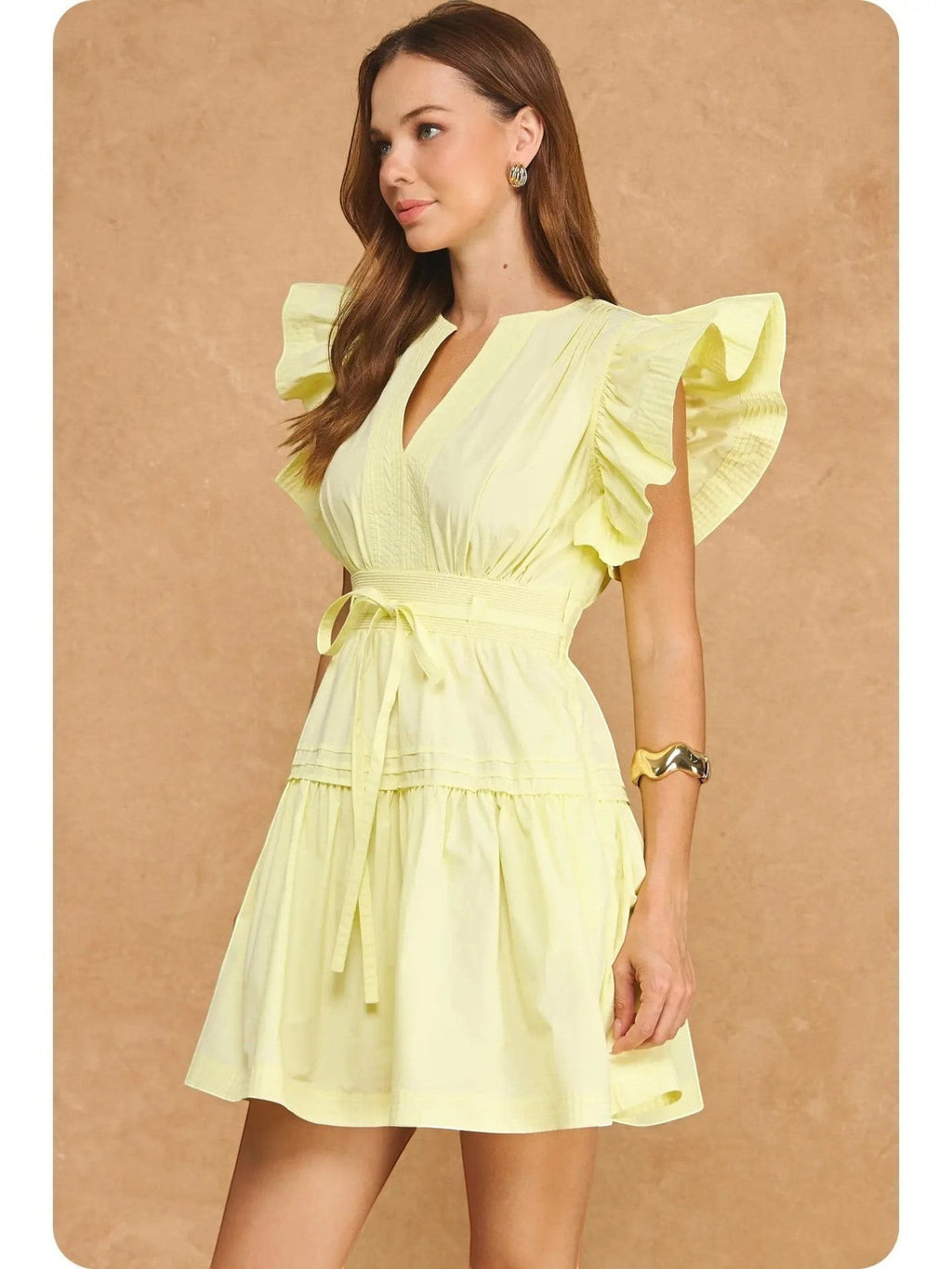 Mialur Valencia dress in butter yellow featuring flutter sleeves, a split V-neckline, and a smocked waist on a model.