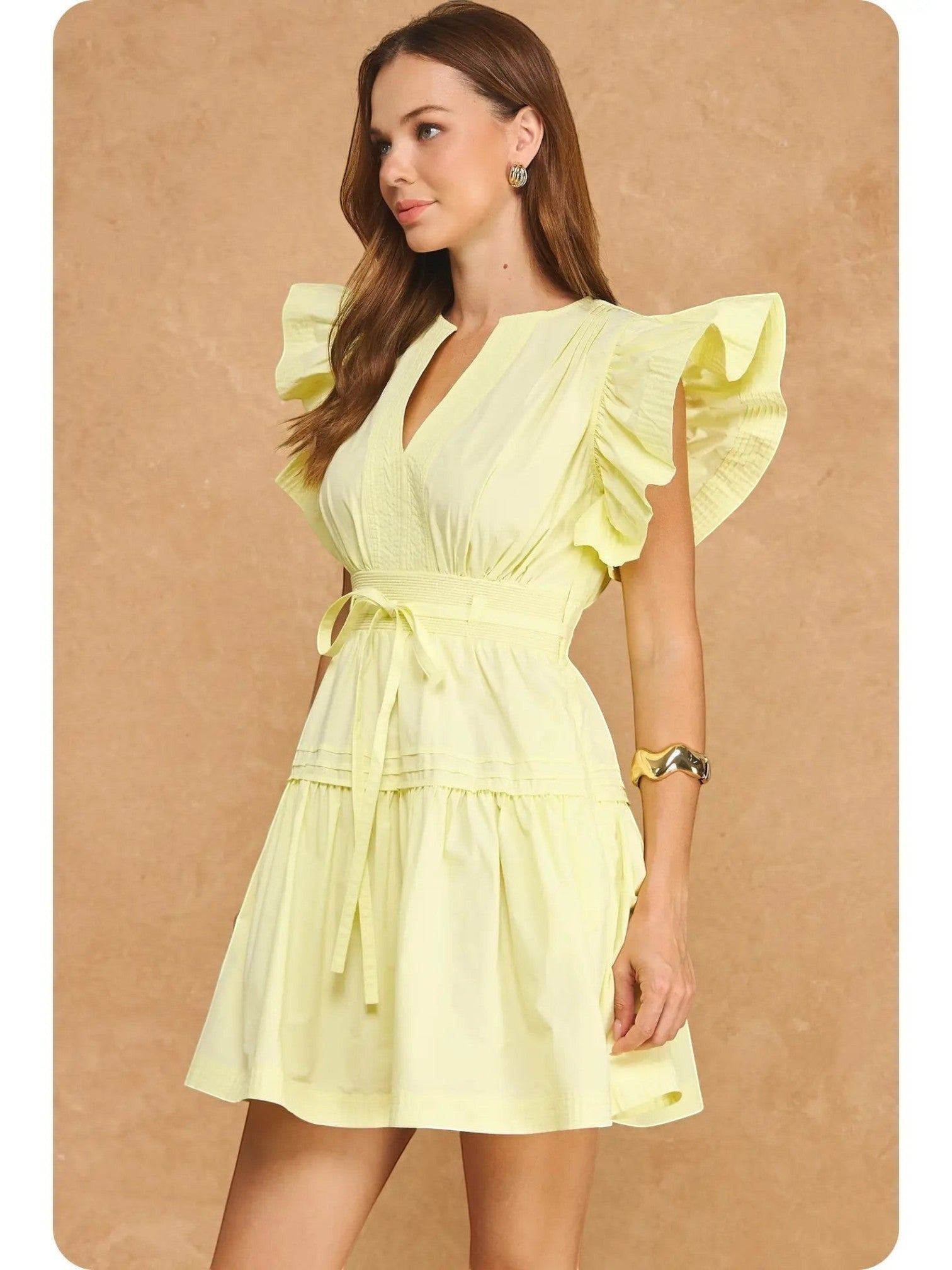 Mialur Valencia dress in butter yellow featuring flutter sleeves, a split V-neckline, and a smocked waist on a model.