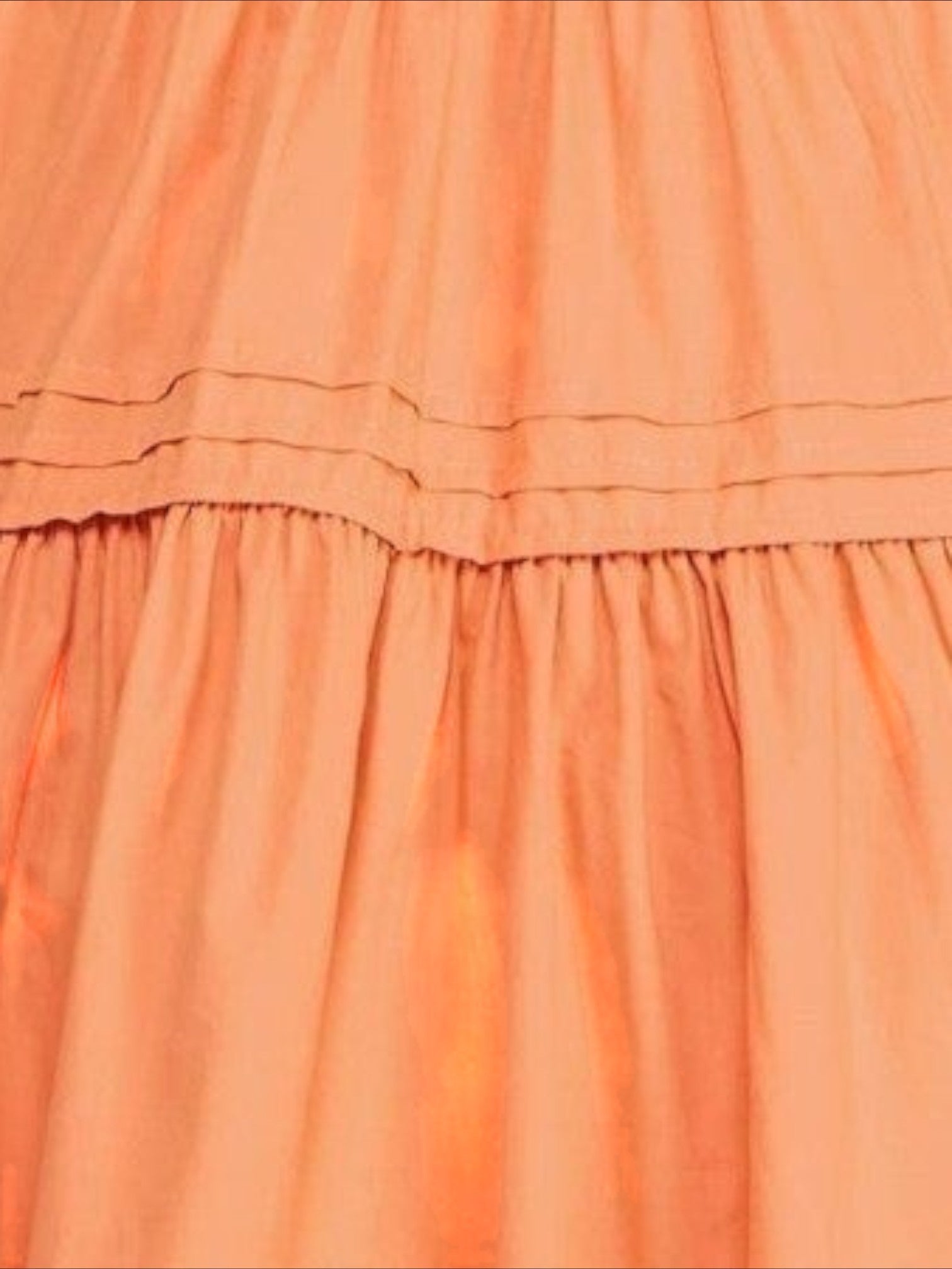 Mialur Valencia dress in cantaloupe orange featuring a flowy tiered skirt with delicate horizontal pleat detailing.