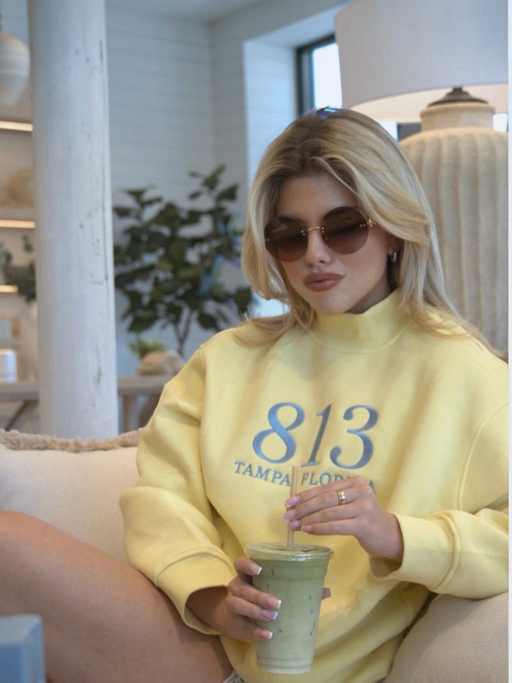 Mialur yellow cotton-blend mock neck sweatshirt with 813 Tampa Florida graphic worn by a blonde woman with sunglasses