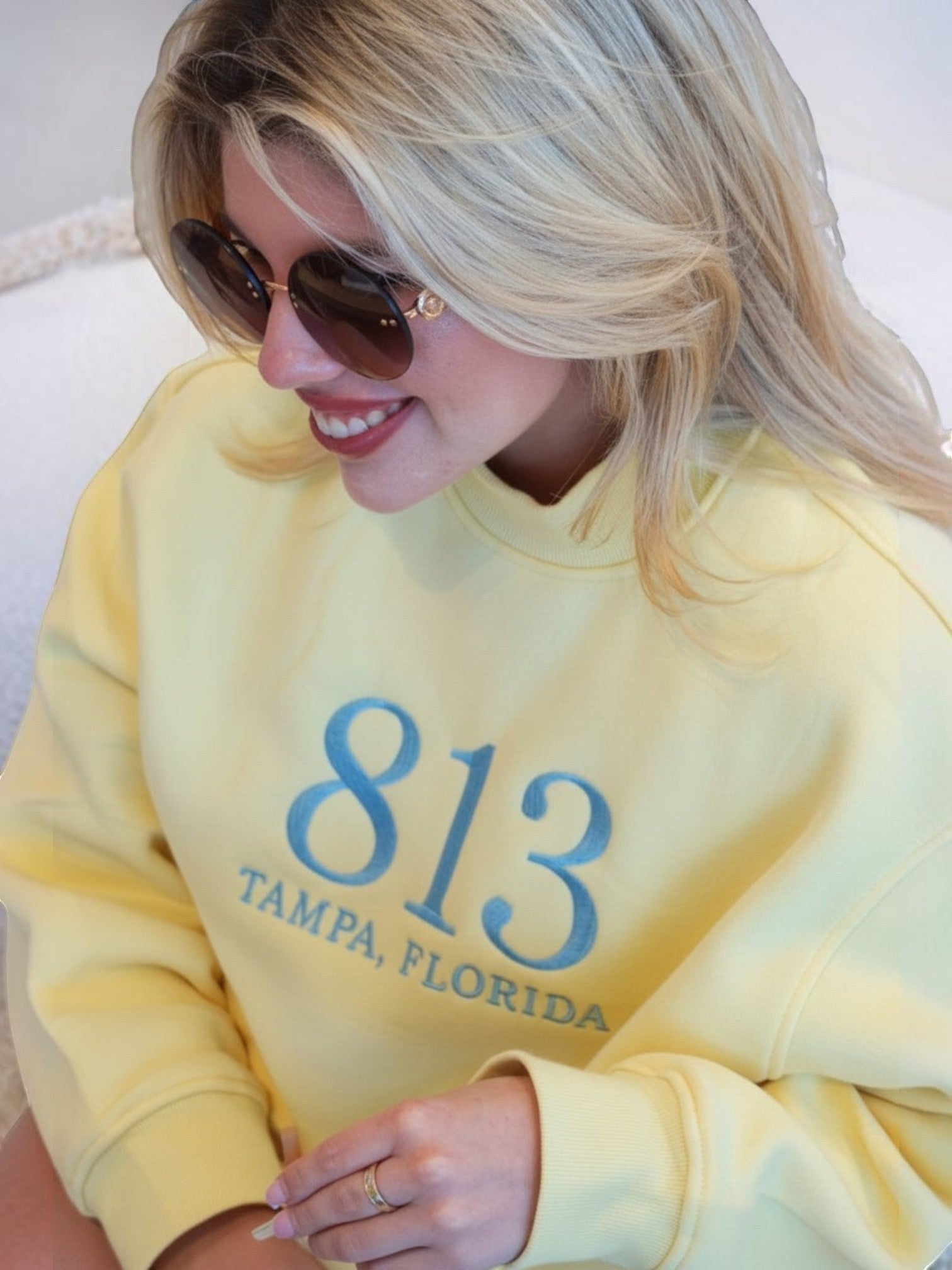 Mialur yellow cotton-blend mock neck sweatshirt with 813 Tampa Florida graphic worn by a blonde woman in sunglasses.
